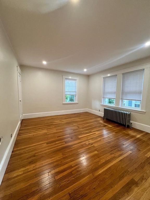 96 Brooks Street, Unit 1 Boston, MA 02135 - Photo 8 of 15 an empty room with wooden floor and windows
