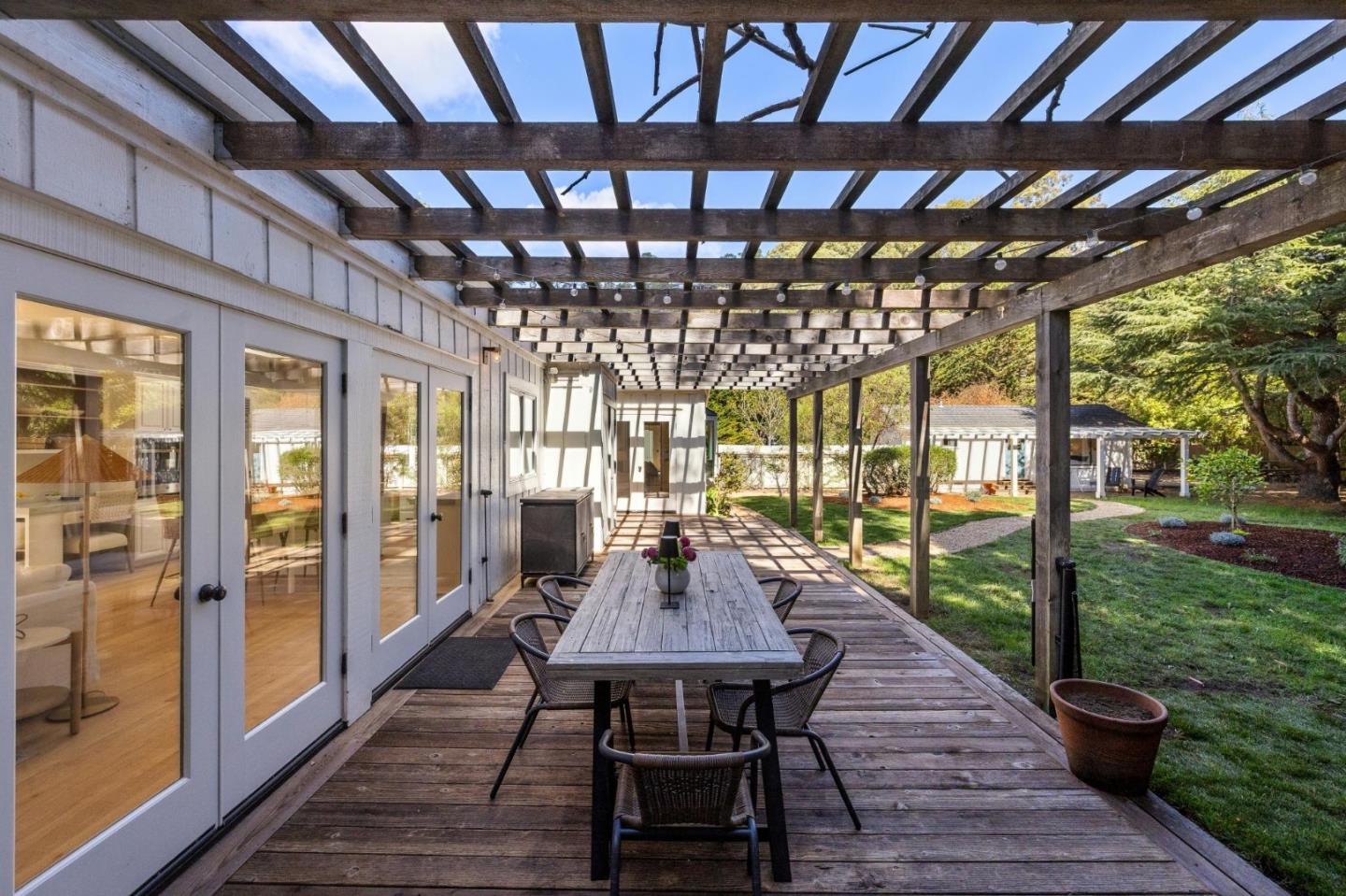 5700 Carmel Valley Road Carmel, CA 93923 - Photo 36 of 66 a view of a patio with table and chairs potted plants with wooden floor and fence