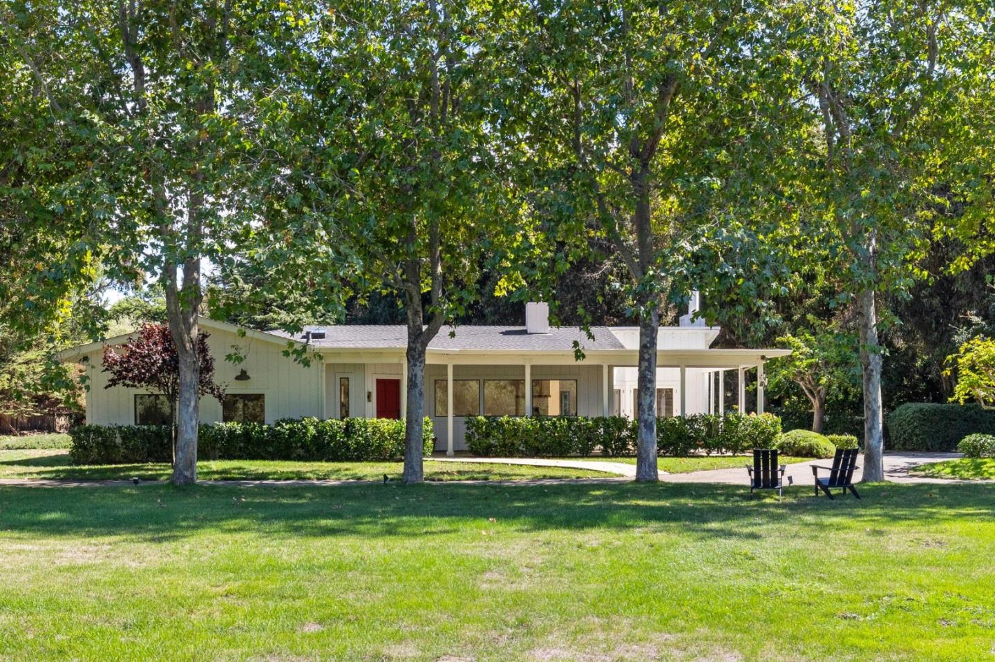 5700 Carmel Valley Road Carmel, CA 93923 - Photo 4 of 66 a front view of a house with a garden and trees