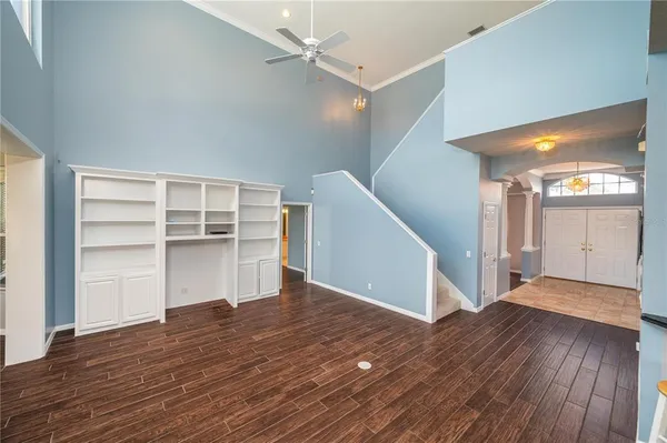 a view of an empty room with wooden floor and closet