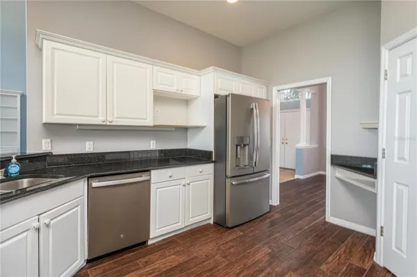 a kitchen with granite countertop white cabinets and a sink