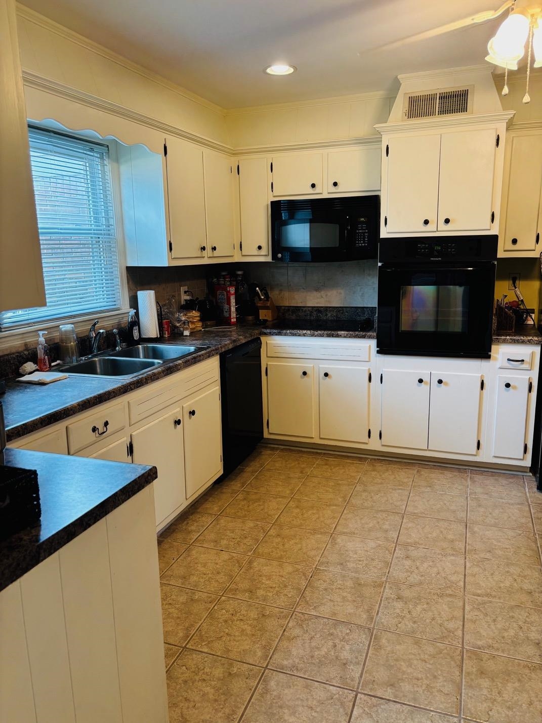 2076 Riverdale Road Germantown, TN 38138 - Photo 5 of 21 Kitchen with black appliances, white cabinets, light tile patterned floors, and backsplash