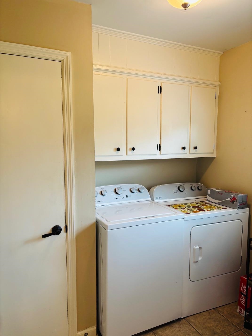 2076 Riverdale Road Germantown, TN 38138 - Photo 6 of 21 Laundry area with washing machine and clothes dryer, cabinet space, and light tile patterned flooring