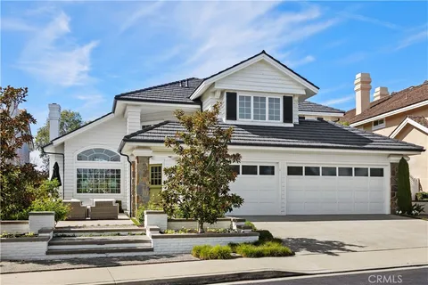 a view of a white house with large windows and a table and chairs