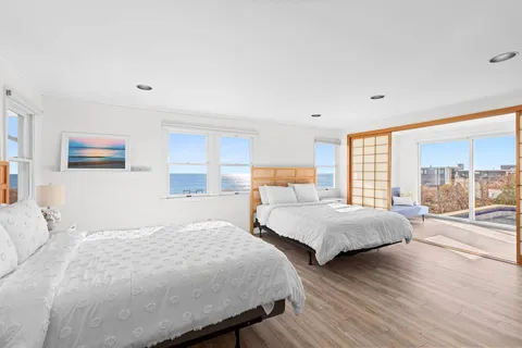 a bedroom with two beds and a large window