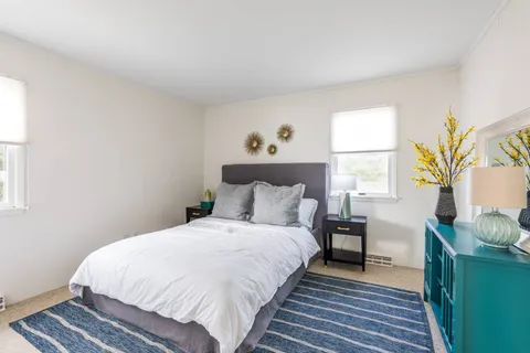 a large bed sitting in a bedroom next to a window