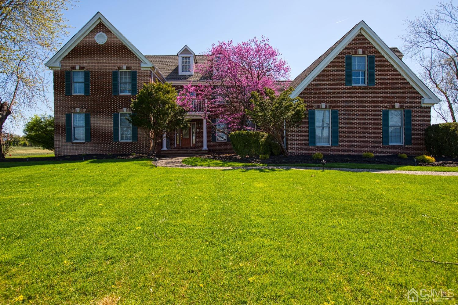 a front view of house with yard and trees in the background