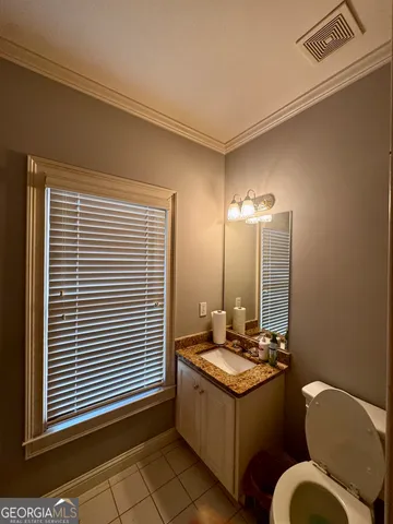 a bathroom with a double vanity sink mirror and toilet
