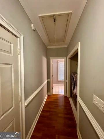 a view of a hallway with wooden floor and staircase