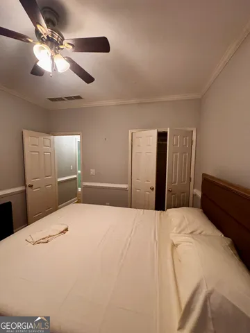 a large bedroom with a bed and a chandelier