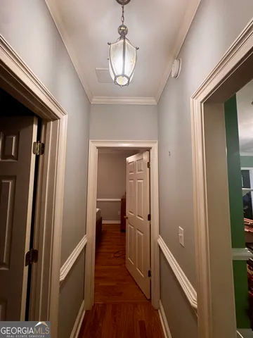 a view of a hallway with wooden floor and staircase