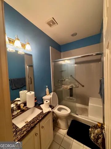 a bathroom with a granite countertop sink mirror vanity and toilet