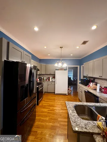 a kitchen with stainless steel appliances granite countertop a sink and a refrigerator