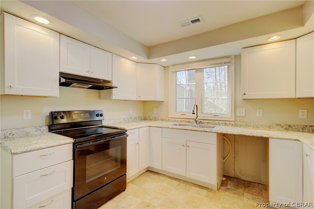 5347 Ware Neck Road Gloucester, VA 23061 - Photo 23 of 36 Kitchen with black / electric stove, sink, custom range hood, and white cabinets