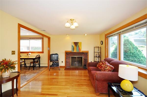 7 Senator Road Woburn, MA 01801 - Photo 2 of 26 a living room with furniture a fireplace and floor to ceiling windows
