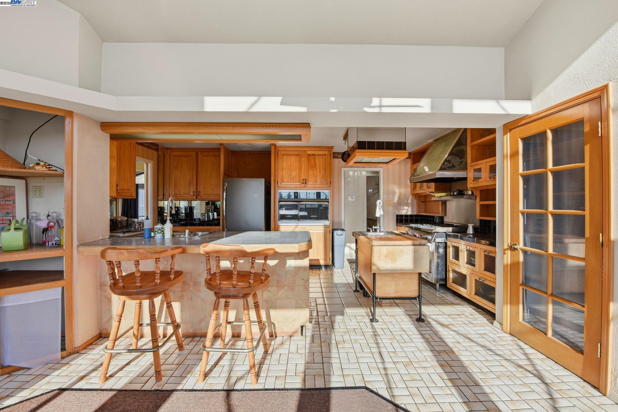 29673 Holiday Street Hayward, CA 94544 - Photo 16 of 47 a kitchen with stainless steel appliances kitchen island granite countertop a table and chairs in it