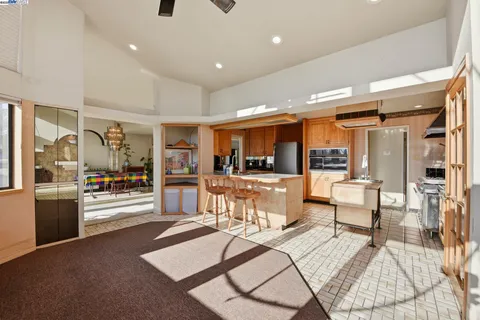 a living room with furniture and a view of kitchen