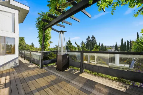 a view of a balcony with chairs and wooden fence