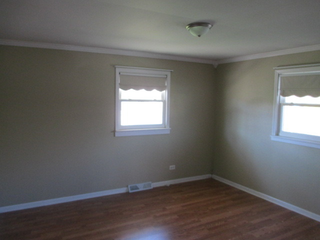 2106 Gideon Avenue Zion, IL 60099 - Photo 9 of 20 a view of an empty room with wooden floor and a window
