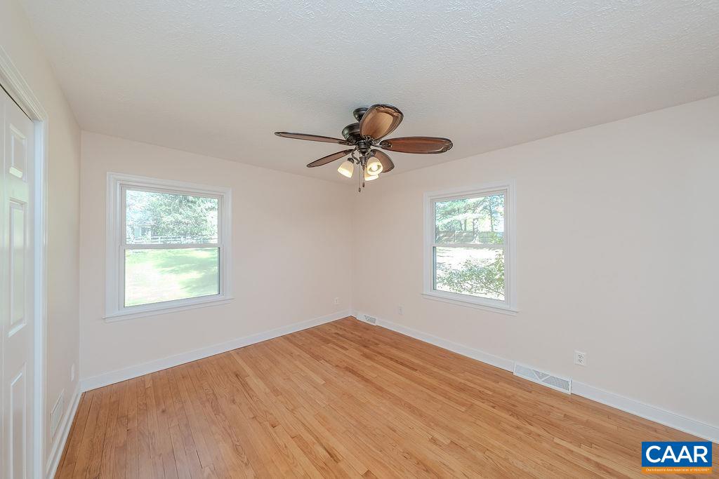 6156 Advance Mills Road Ruckersville, VA 22968 - Photo 16 of 54 a view of empty room with wooden floor and fan