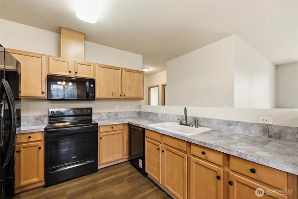 a kitchen with granite countertop a stove top oven sink and cabinets