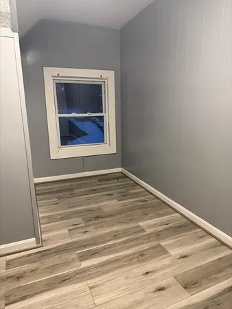 a view of a small space with wooden floor and a window