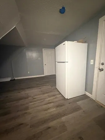 a view of a refrigerator in kitchen and wooden floor