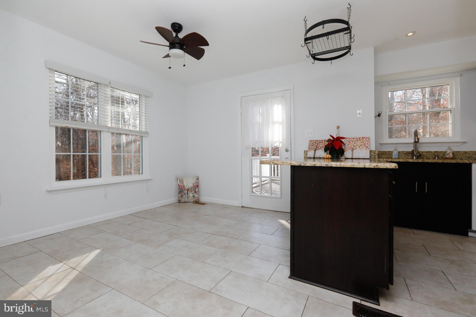 15334 Inlet Place Dumfries, VA 22025 - Photo 6 of 32 a kitchen with kitchen island granite countertop a sink cabinets and window
