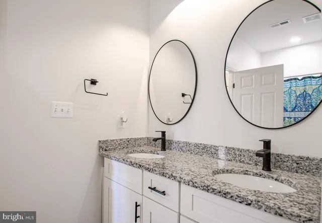 an empty room with wooden floor chandelier fan and windows