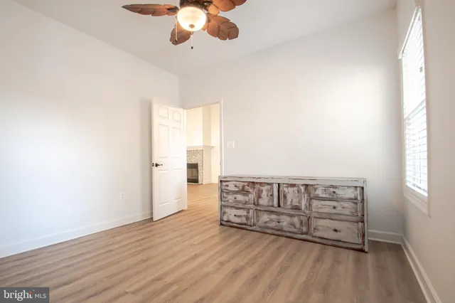 a view of empty room with wooden floor and fireplace