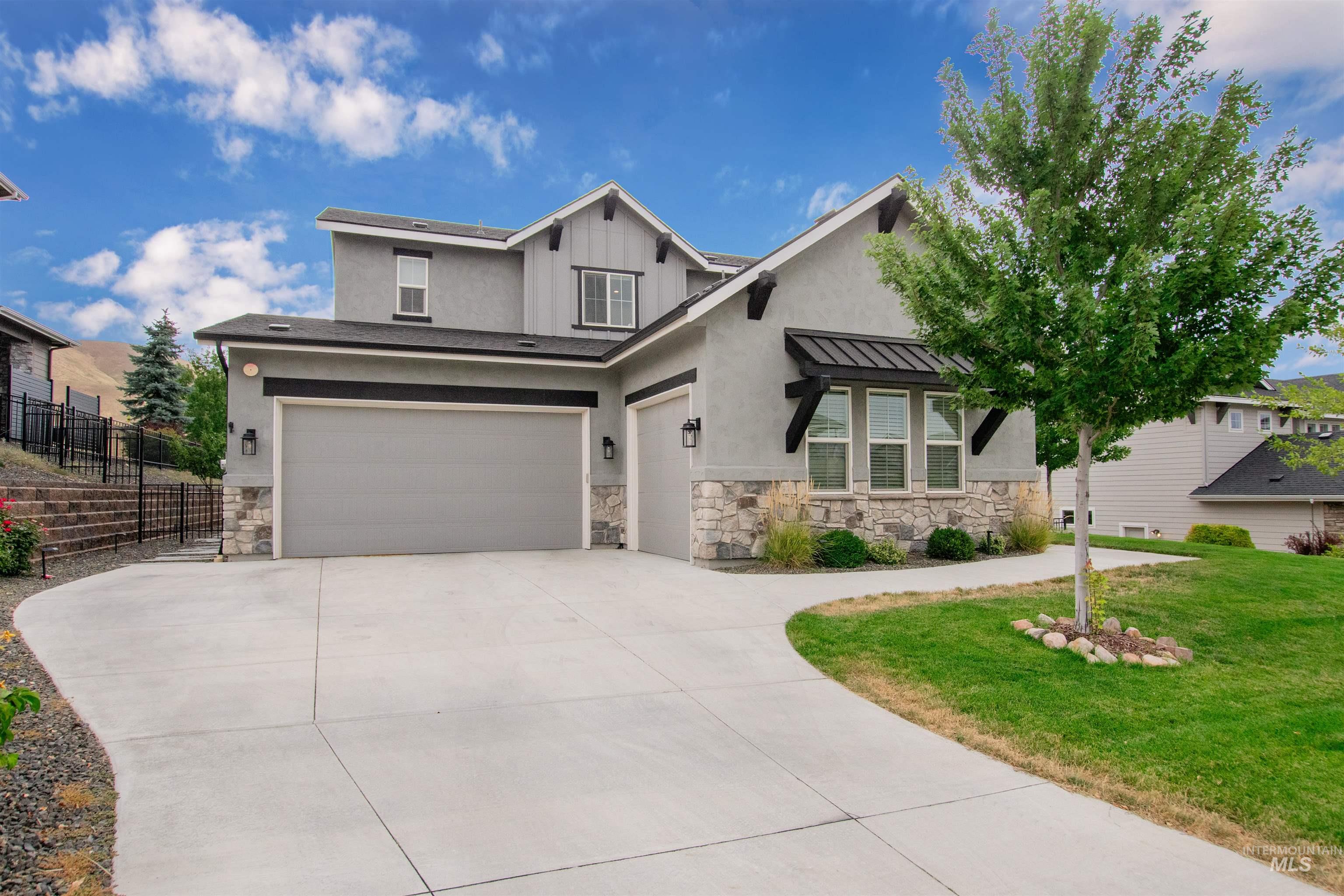 2400 South Trapper Place Boise, ID 83716 - Photo 3 of 50 View of front of house featuring a garage, stone siding, a standing seam roof, and driveway