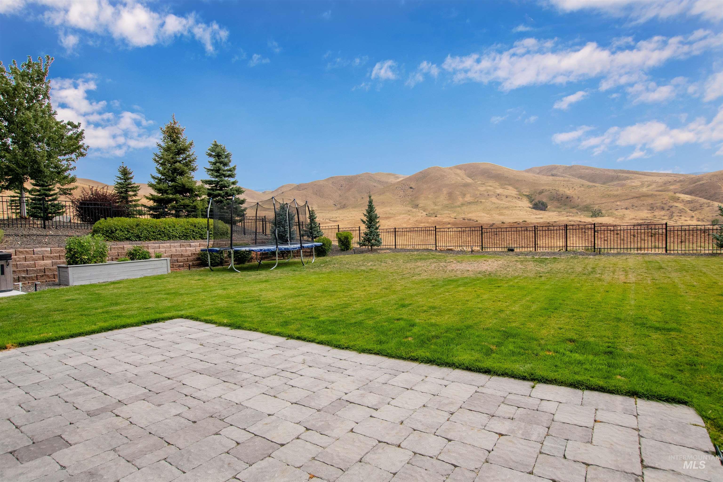 2400 South Trapper Place Boise, ID 83716 - Photo 43 of 50 Fenced backyard with a patio, a trampoline, and a mountain view