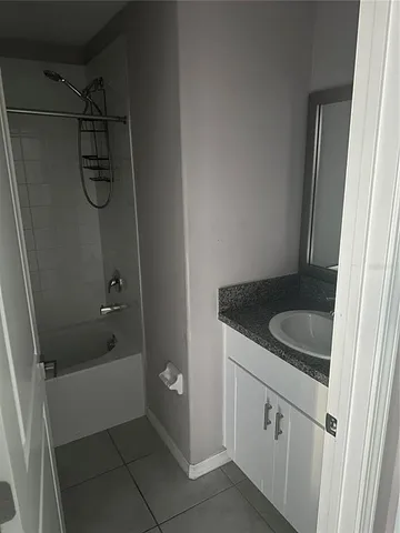 a bathroom with a granite countertop sink a toilet and shower