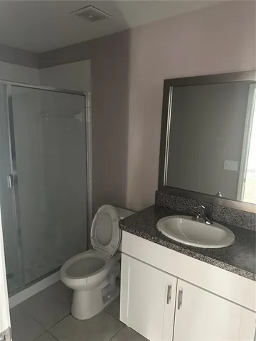 a bathroom with a granite countertop sink toilet and a mirror