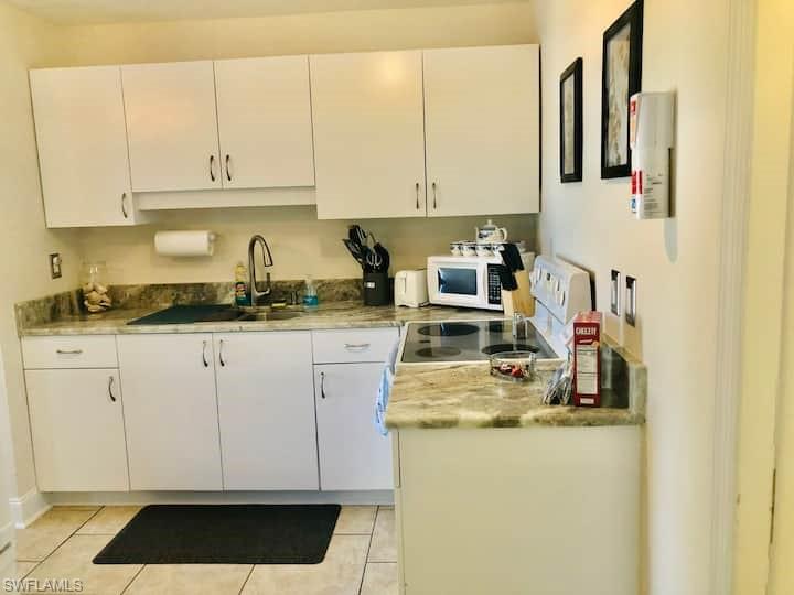 1726 Bikini Court, Unit R Cape Coral, FL 33904 - Photo 5 of 14 a kitchen with stainless steel appliances granite countertop a sink and cabinets