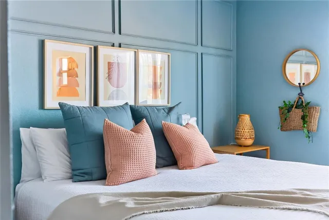 a bedroom with a bed mirror and window