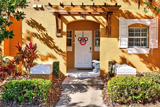 a front view of a house with a yard and potted plants