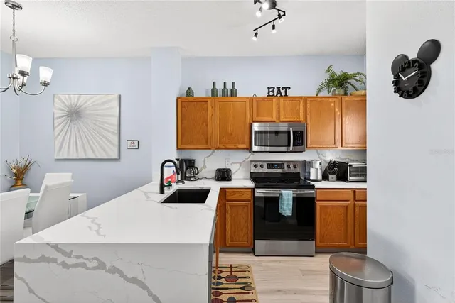 a kitchen with stainless steel appliances granite countertop a sink and a stove