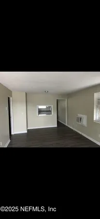 a view of an empty room with wooden floor