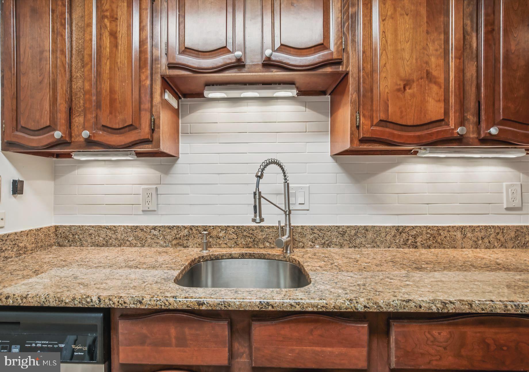 1077 30th Street Northwest, Unit 612 Washington, DC 20007 - Photo 15 of 44 a kitchen with granite countertop a sink and a stove