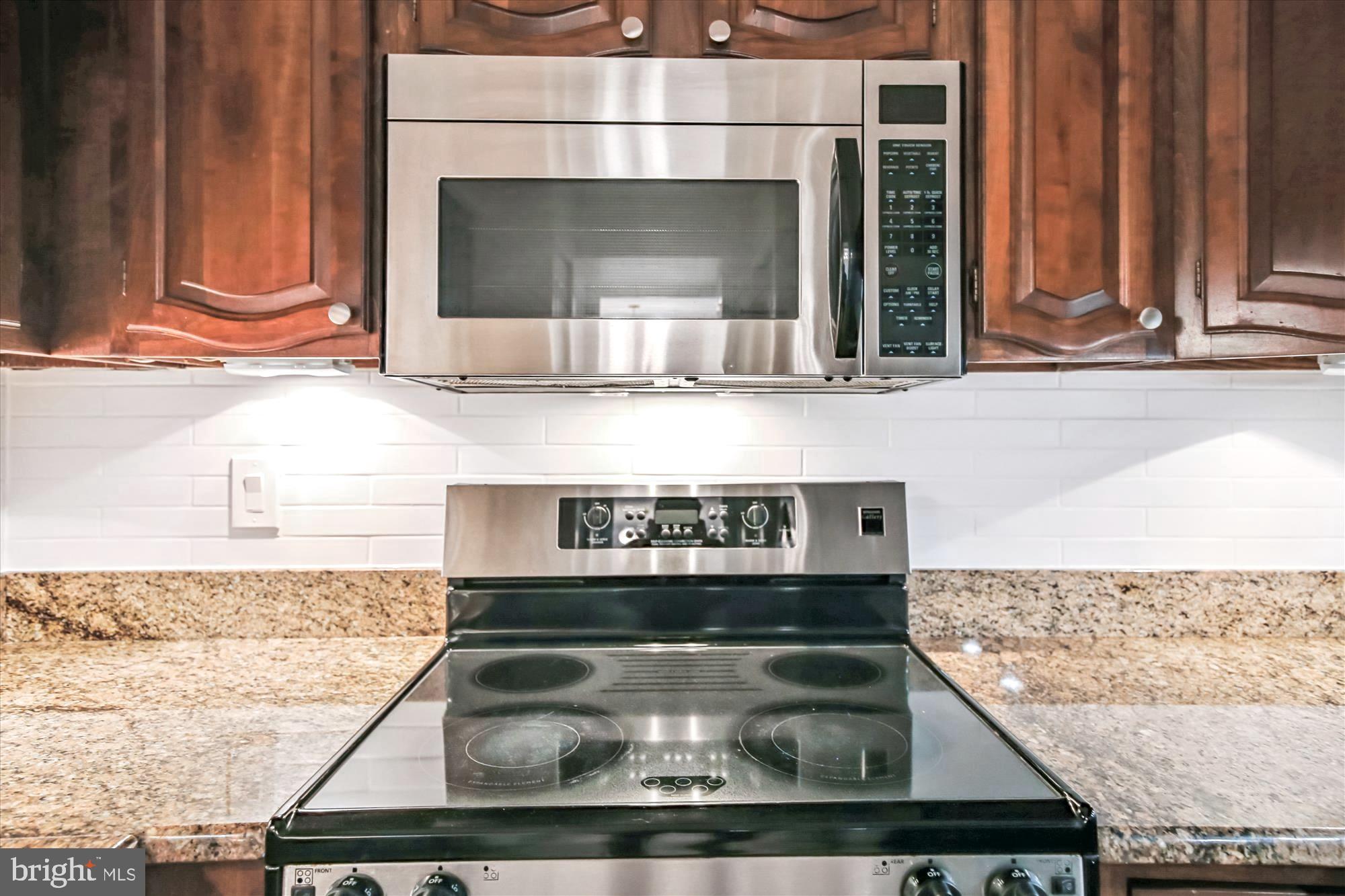 1077 30th Street Northwest, Unit 612 Washington, DC 20007 - Photo 19 of 44 a kitchen with a stove and a microwave