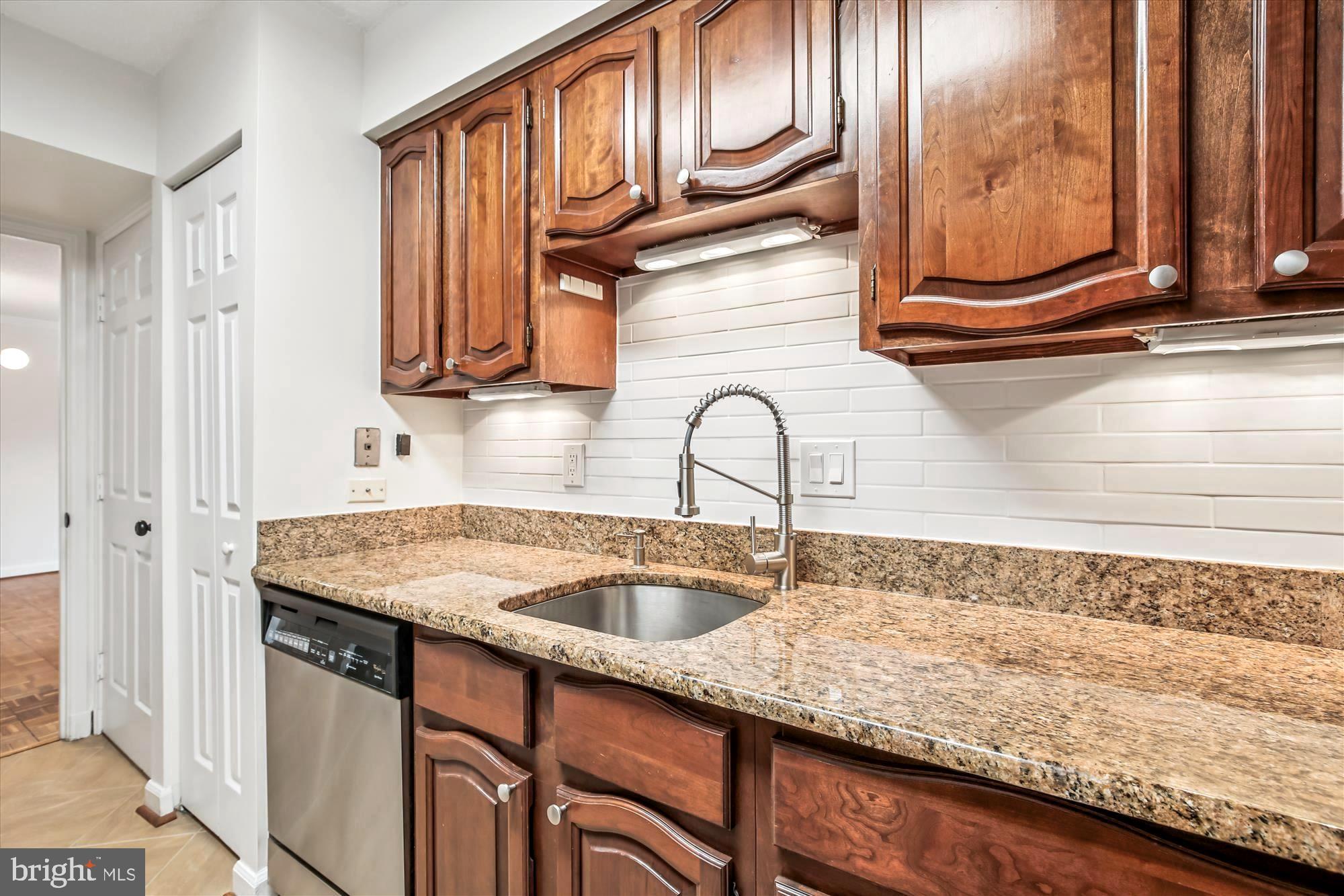 1077 30th Street Northwest, Unit 612 Washington, DC 20007 - Photo 20 of 44 a kitchen with stainless steel appliances granite countertop a sink and cabinets