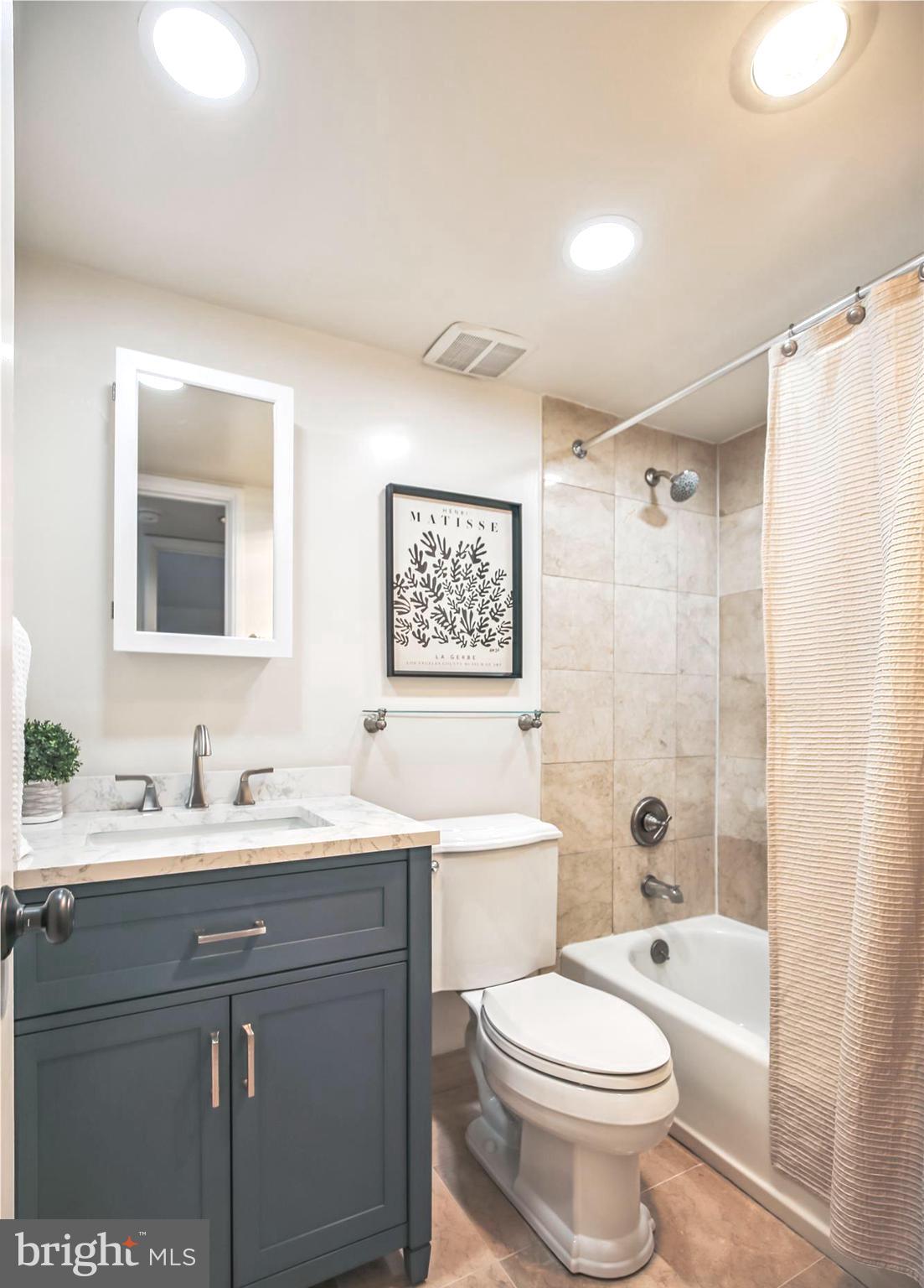 1077 30th Street Northwest, Unit 612 Washington, DC 20007 - Photo 25 of 44 a bathroom with a double vanity sink toilet mirror and shower