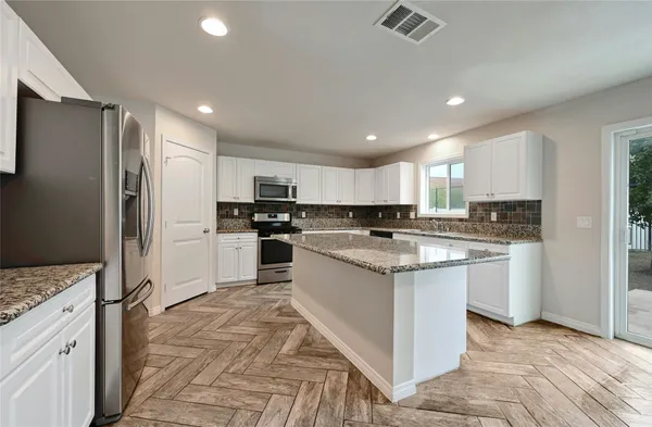 a kitchen with white cabinets and stainless steel appliances