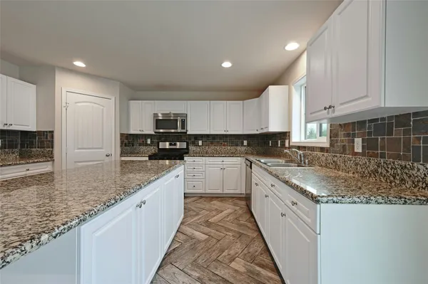 a kitchen with stainless steel appliances granite countertop a refrigerator and a stove top oven