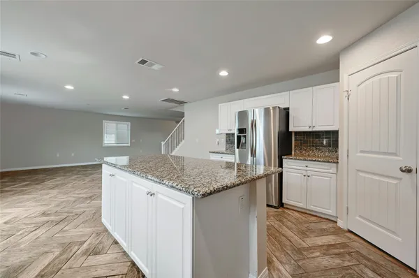 a large kitchen with granite countertop lots of counter space sink and cabinets