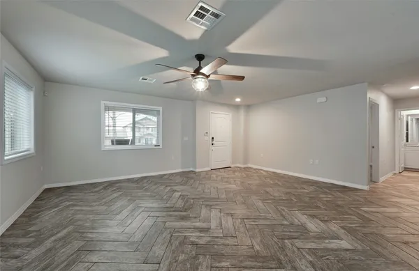 an empty room with fan and windows