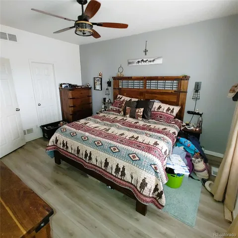a bedroom with a bed and wooden floor