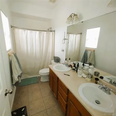 a bathroom with a double vanity sink mirror and toilet