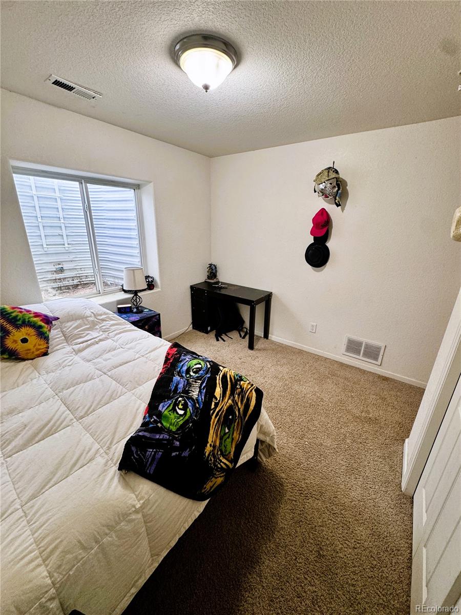 1451 Challenger Drive Pueblo West, CO 81007 - Photo 7 of 26 a bedroom with a bed and window